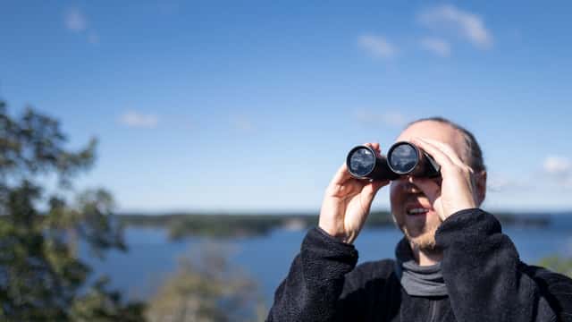 Man vid havet tittar i kikare, Järfälla, Stockholm.